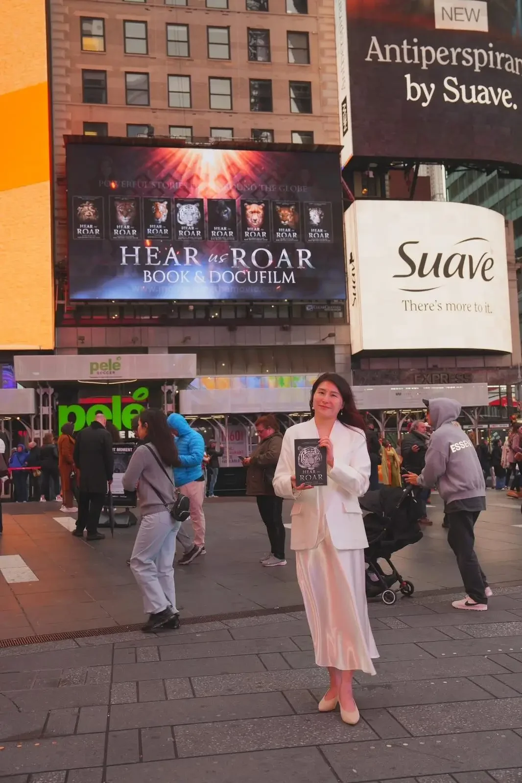 Carrie in Times Square beneath the Hear Us Roar billboard