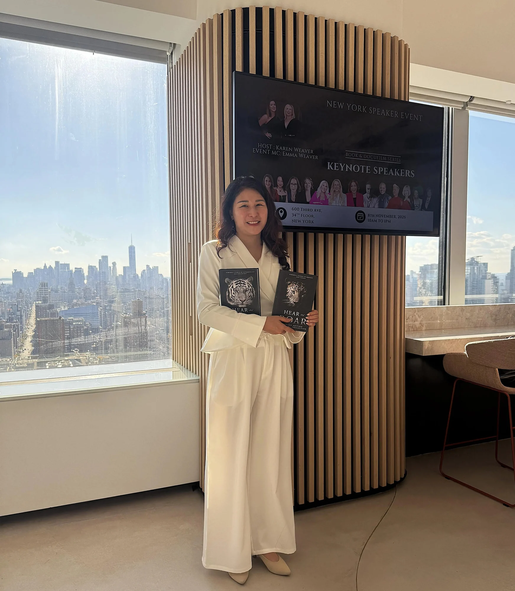 Carrie holding Hear Us Roar books at a New York keynote speakers event