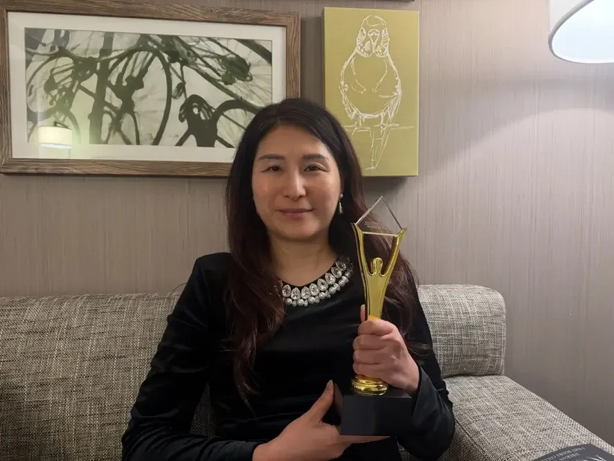 Carrie holding her Stevie Award trophy