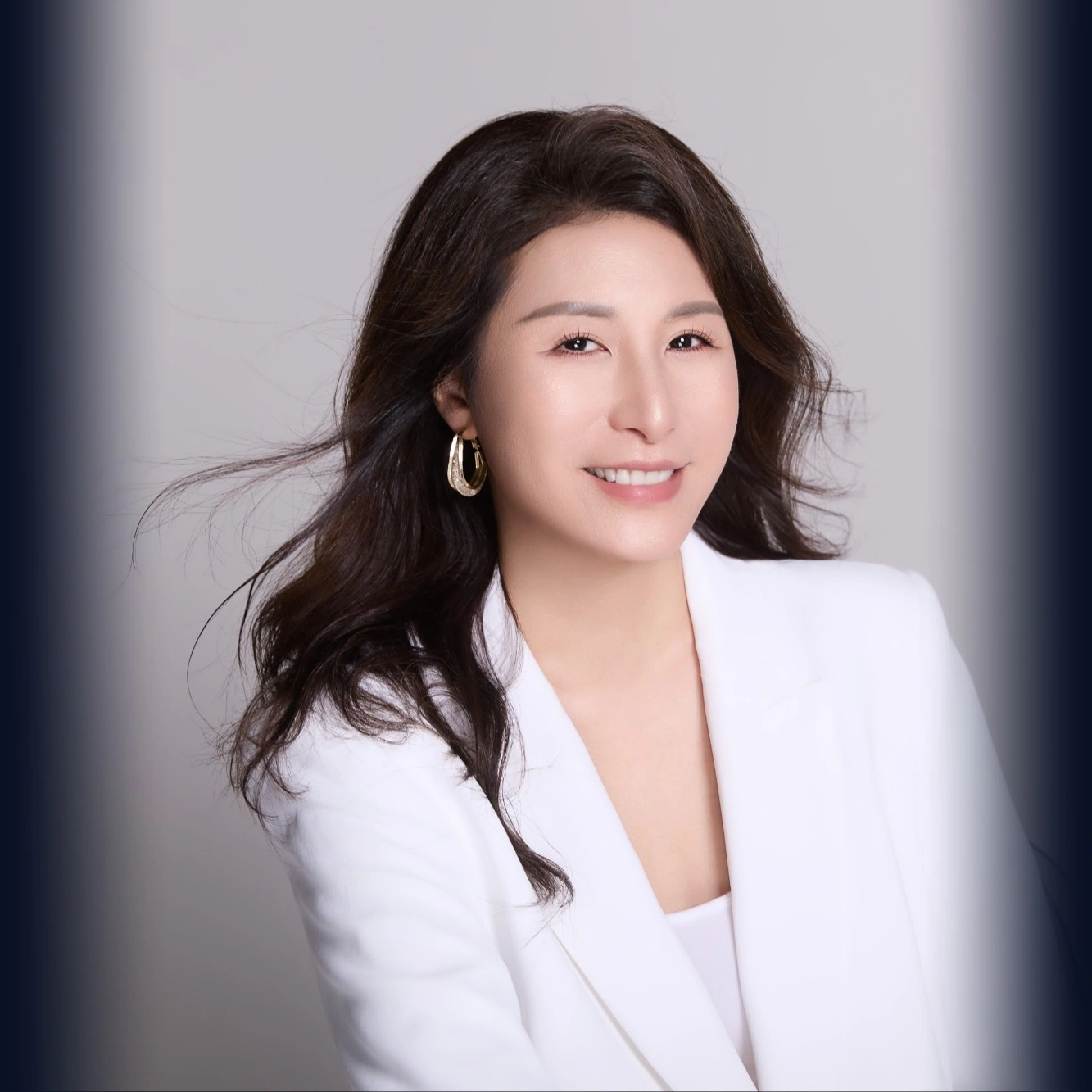 Carrie Anne Yu in a white blazer, smiling