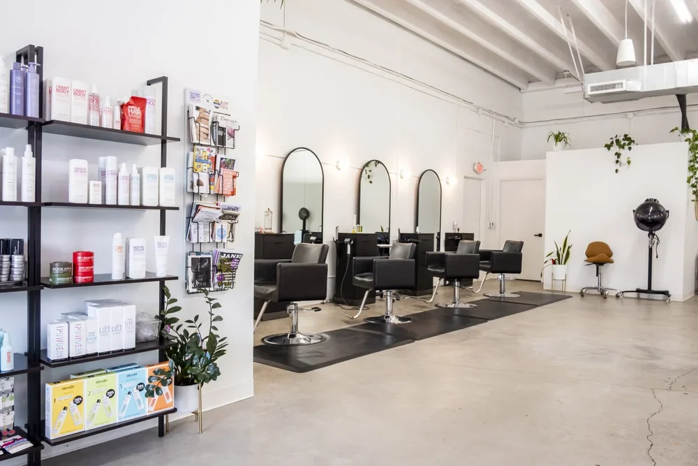 Bright Acute Salon interior with styling chairs, mirrors and colorful product displays